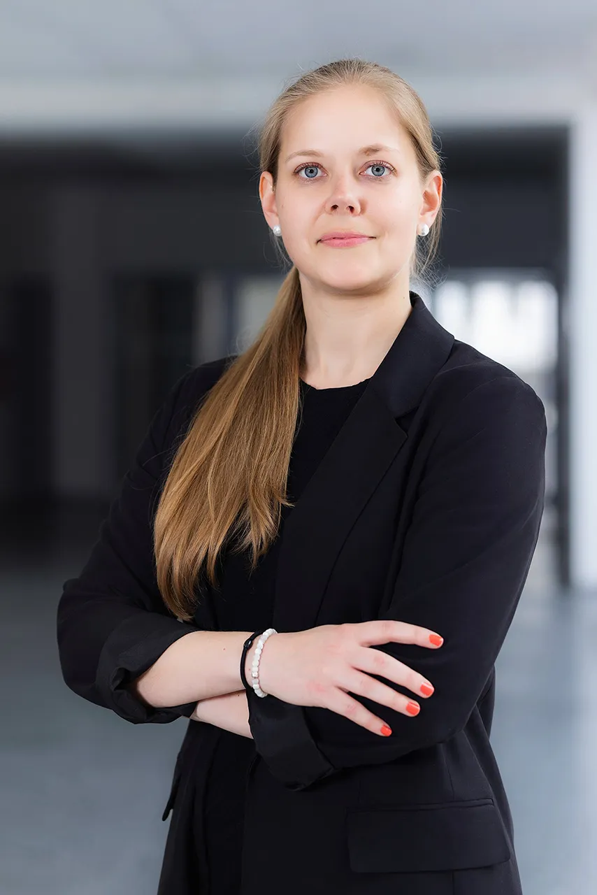 Žena v tmavém saku a založenýma rukama, byznys portrét v pracovním prostředí